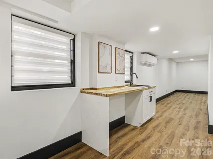 a view of empty room with wooden floor and fireplace