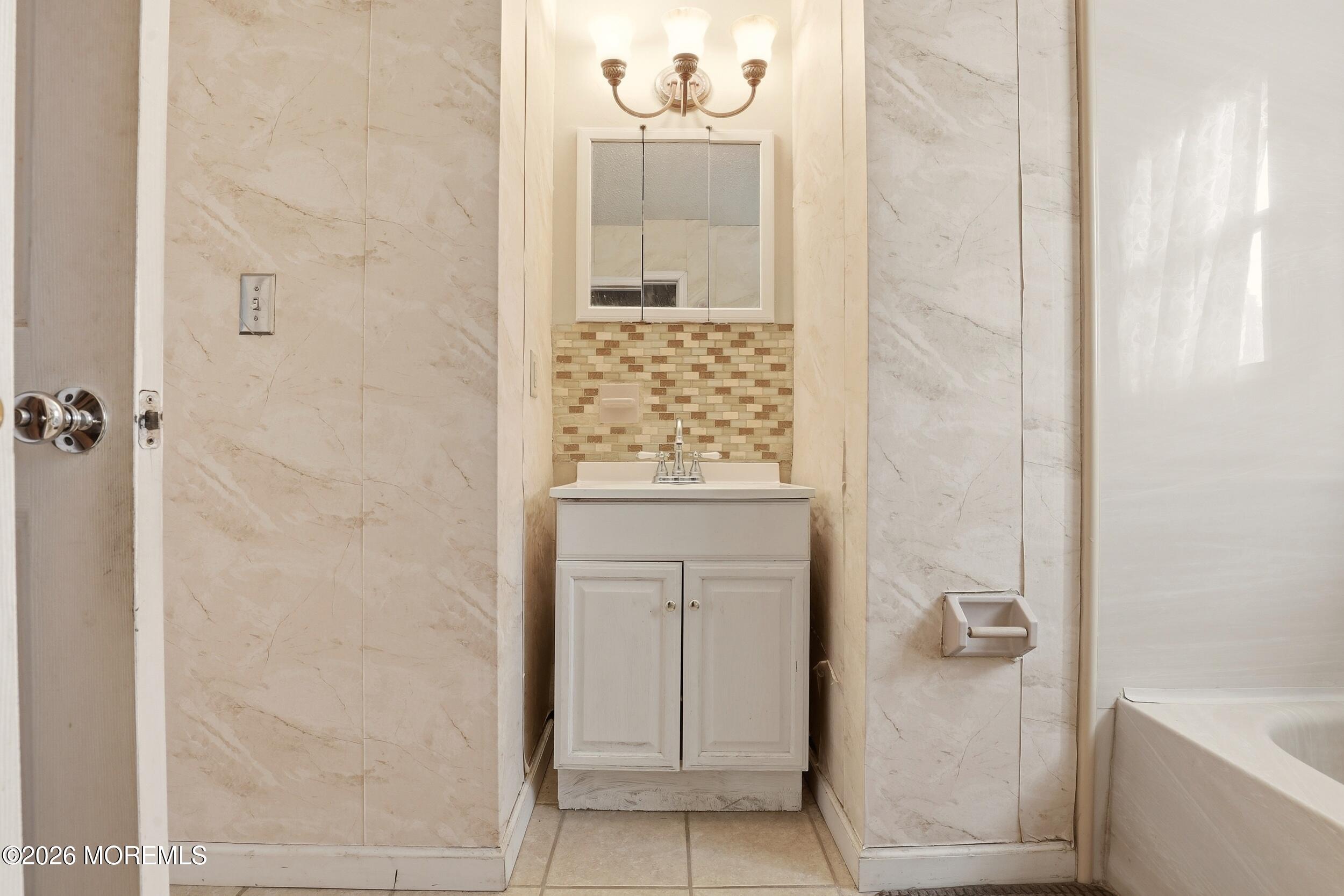 1 Mimi Lane Howell, NJ 07731 - Photo 20 of 26 a bathroom with a granite countertop sink a mirror and shower