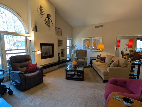 a living room with furniture a fireplace and a large window