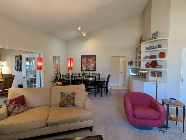 a living room with furniture and a dining table with kitchen view