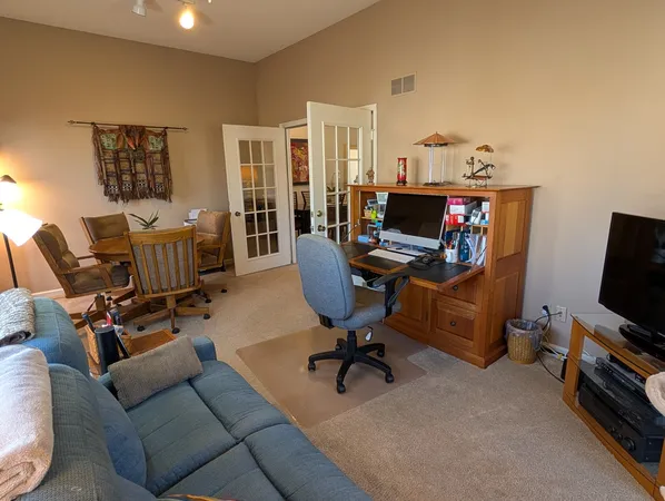 a work room with furniture and a flat screen tv