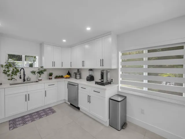 a kitchen with granite countertop white cabinets and white appliances