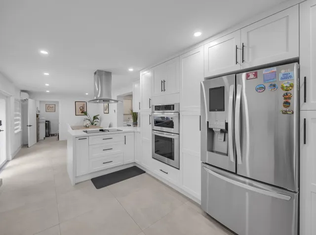 a kitchen with stainless steel appliances white cabinets and a refrigerator