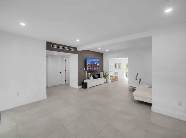 a living room with furniture and a hallway