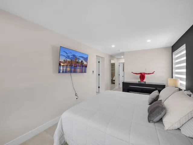 a bedroom with a bed and a painting on the wall