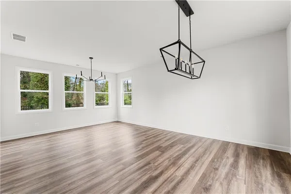 a view of a room with wooden floor exposed radiator and a window