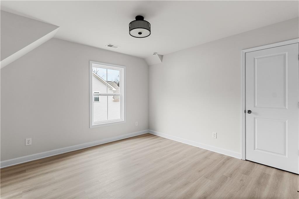 3810 Cottage Circle Clarkston, GA 30021 - Photo 6 of 11 an empty room with wooden floor and windows