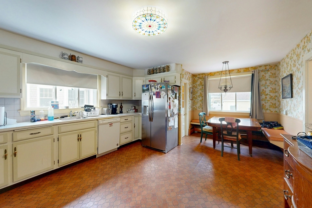 264 Court Road Winthrop, MA 02152 - Photo 7 of 26 a kitchen with stainless steel appliances granite countertop a refrigerator a sink dishwasher a dining table and chairs with wooden floor