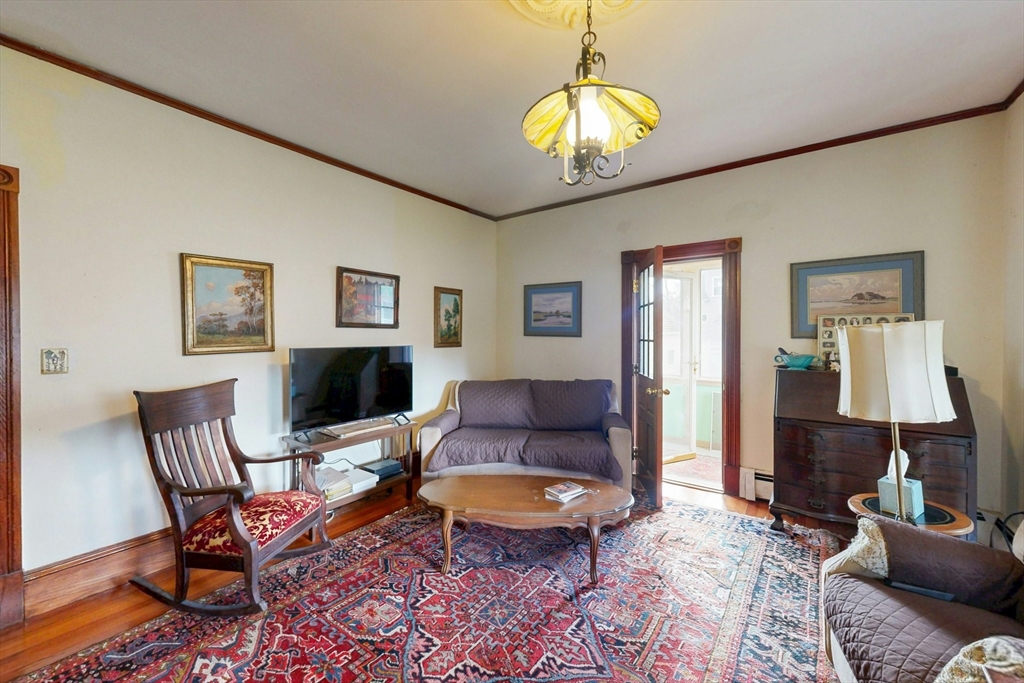 264 Court Road Winthrop, MA 02152 - Photo 10 of 26 a living room with furniture and a chandelier