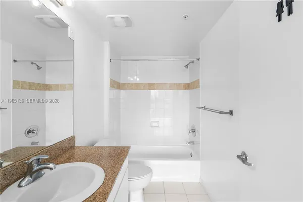 a bathroom with a granite countertop sink mirror and a bathtub