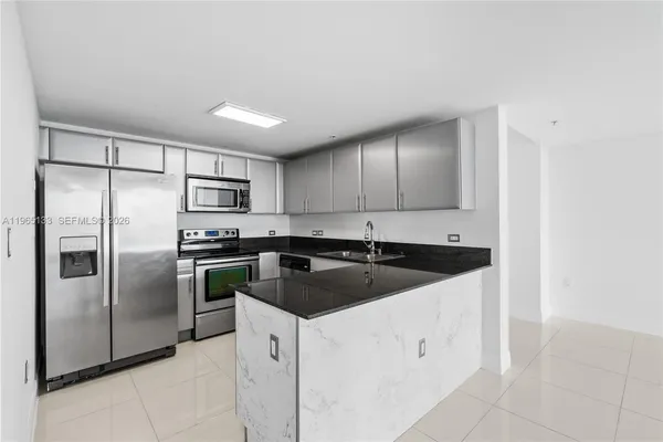 a kitchen with a sink a refrigerator and cabinets