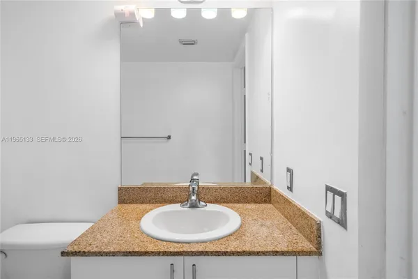 a bathroom with a granite countertop sink and a mirror