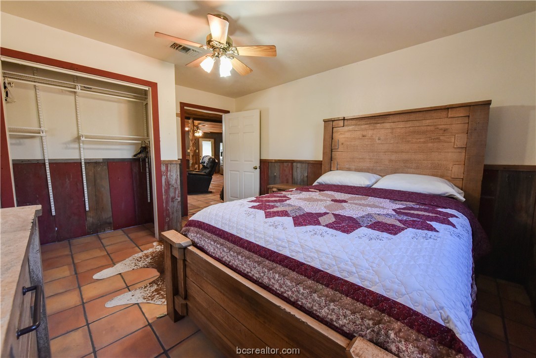 12200 Winn Road Kosse, TX 76653 - Photo 9 of 34 a bedroom with a bed and a chandelier