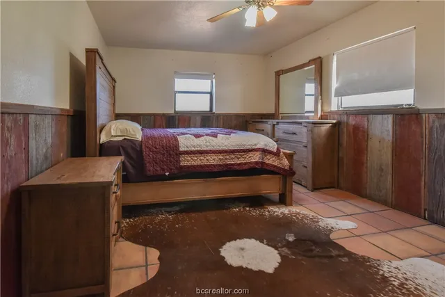 a bedroom with a bed dresser and a window