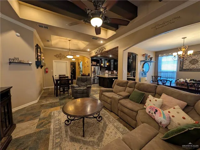 a living room with furniture a chandelier and a dining room