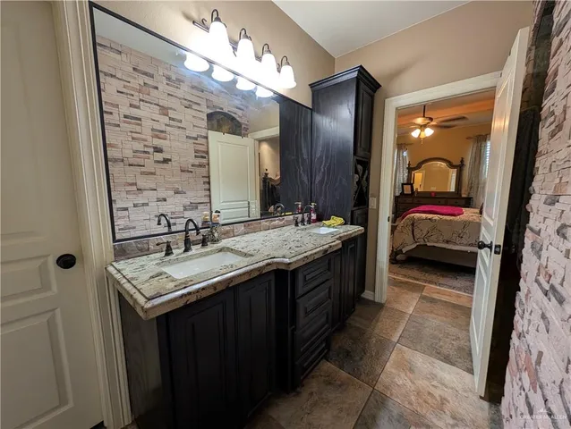 a en suite bathroom with a double vanity sink and a mirror