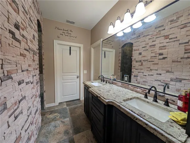 a bathroom with a granite countertop sink a large mirror and a shower