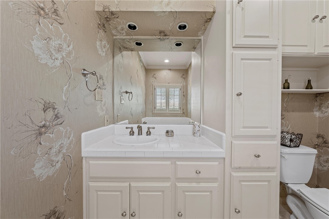 7110 Fish Pond Road Waco, TX 76710 - Photo 16 of 44 a bathroom with a sink and a mirror with toilet