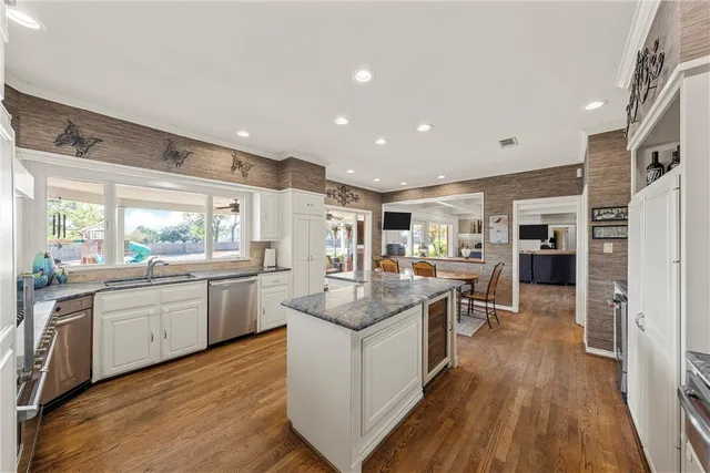 a kitchen with stainless steel appliances granite countertop sink stove top oven and refrigerator