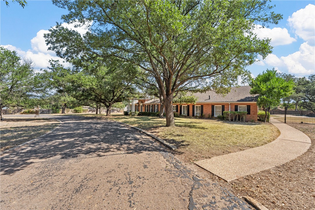 7110 Fish Pond Road Waco, TX 76710 - Photo 3 of 44 a front view of a house with a garden