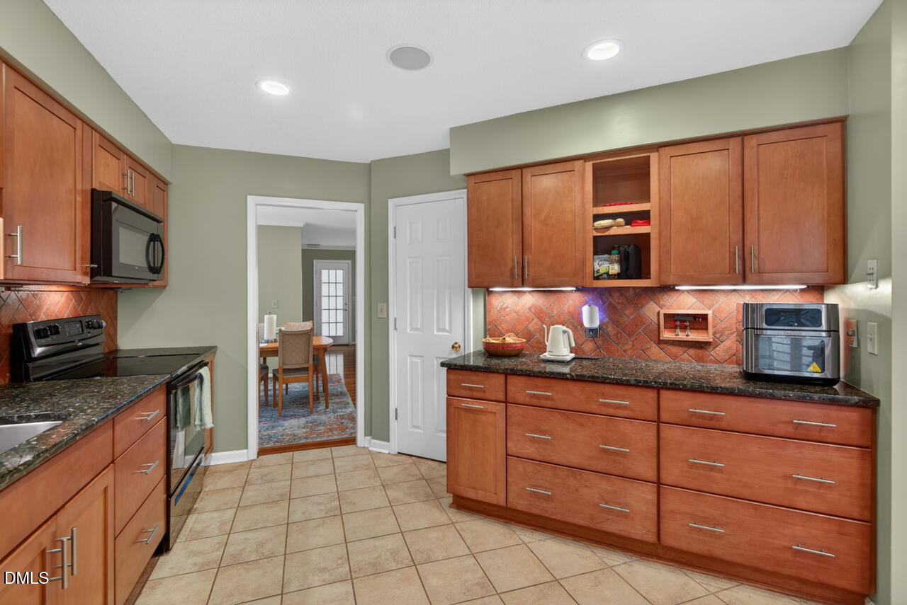 3307 Coachman's Way Durham, NC 27705 - Photo 9 of 50 a kitchen with stainless steel appliances granite countertop a stove a sink and a microwave