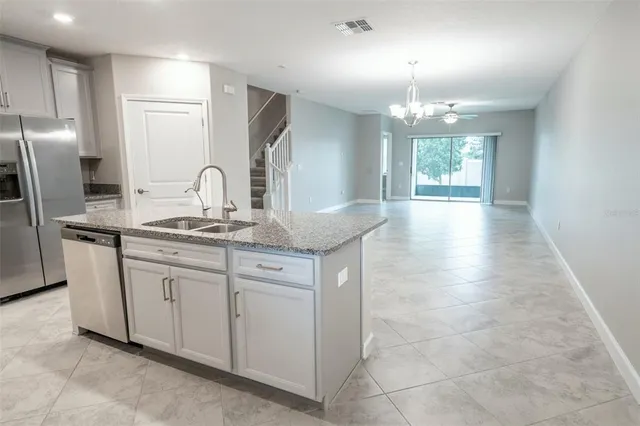 a kitchen with stainless steel appliances granite countertop a sink and a refrigerator