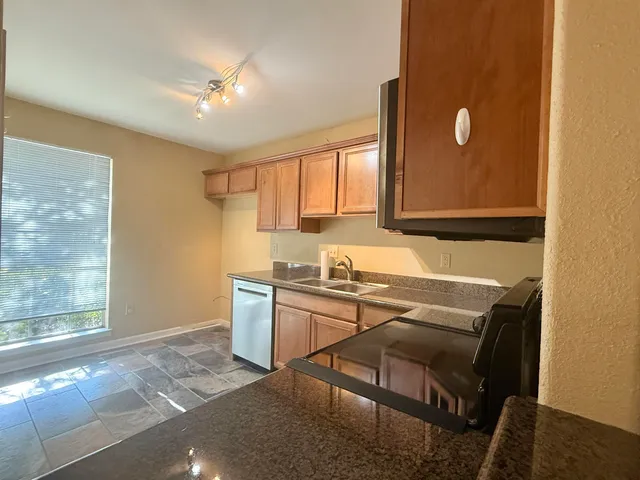 a kitchen with stainless steel appliances granite countertop a sink stove and cabinets