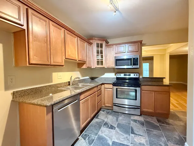 a kitchen with stainless steel appliances granite countertop a stove a sink and a refrigerator