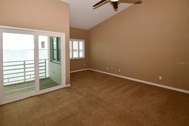 an empty room with a ceiling fan and carpet