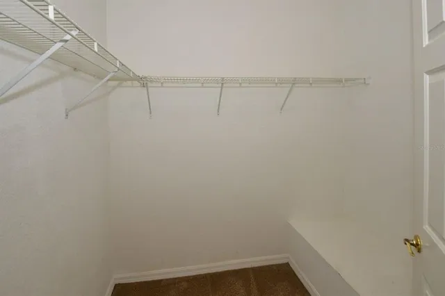 an empty room with a ceiling fan and a window