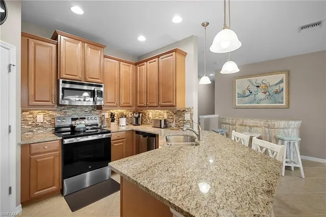 a kitchen with stainless steel appliances granite countertop a stove top oven a sink dishwasher and white cabinets with wooden floor