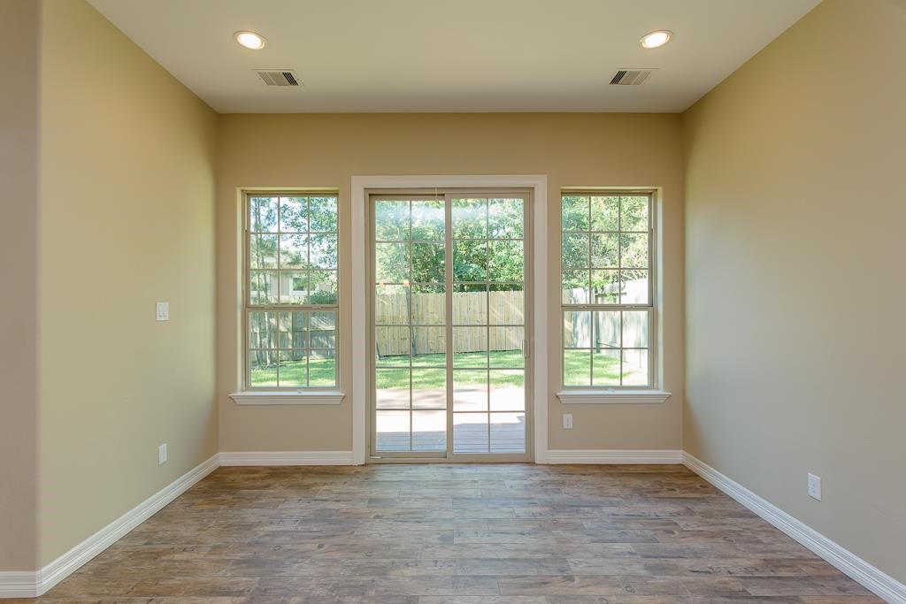 8403 Oak Knot Drive Spring, TX 77389 - Photo 14 of 31 an empty room with wooden floor and windows