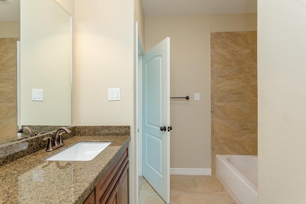 8403 Oak Knot Drive Spring, TX 77389 - Photo 24 of 31 a bathroom with a granite countertop tub sink and mirror