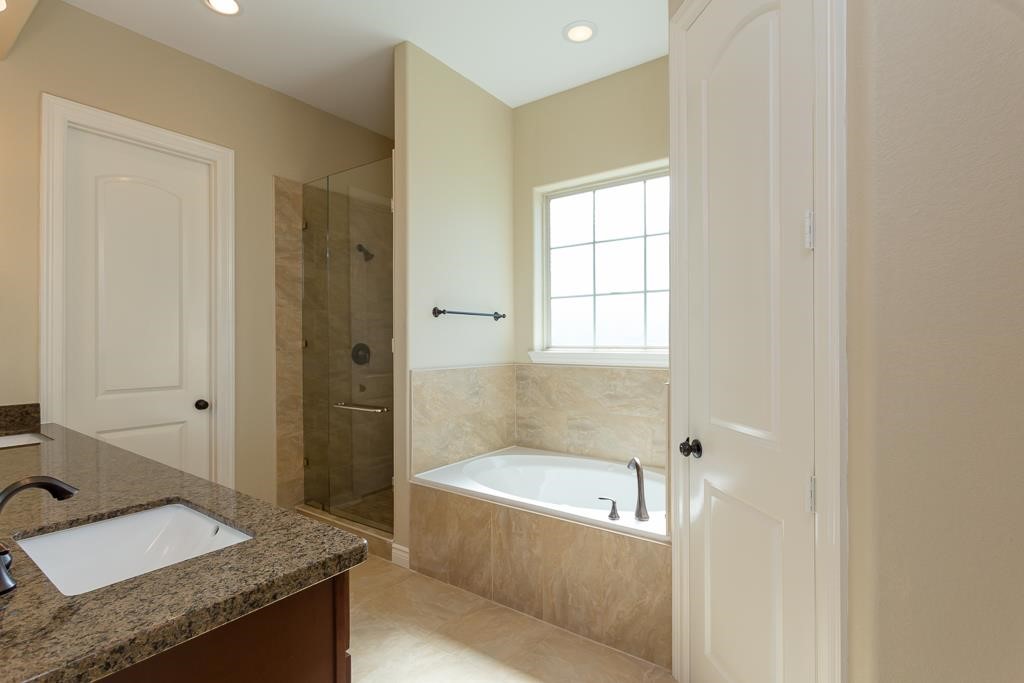 8403 Oak Knot Drive Spring, TX 77389 - Photo 27 of 31 a bathroom with a granite countertop tub sink and mirror