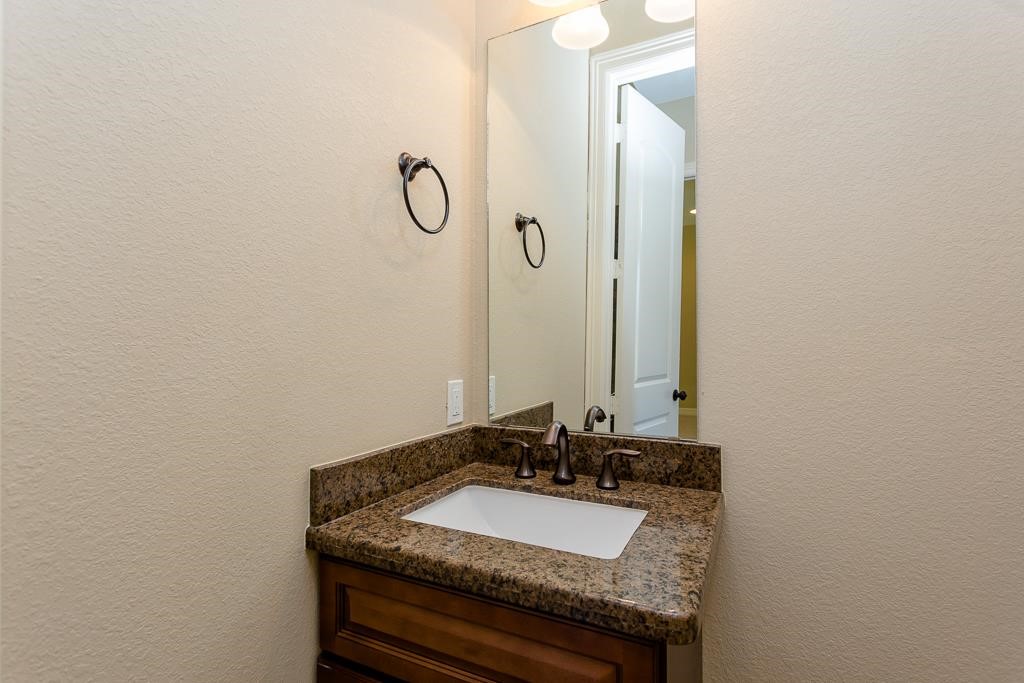 8403 Oak Knot Drive Spring, TX 77389 - Photo 6 of 31 a bathroom with a granite countertop sink and a mirror