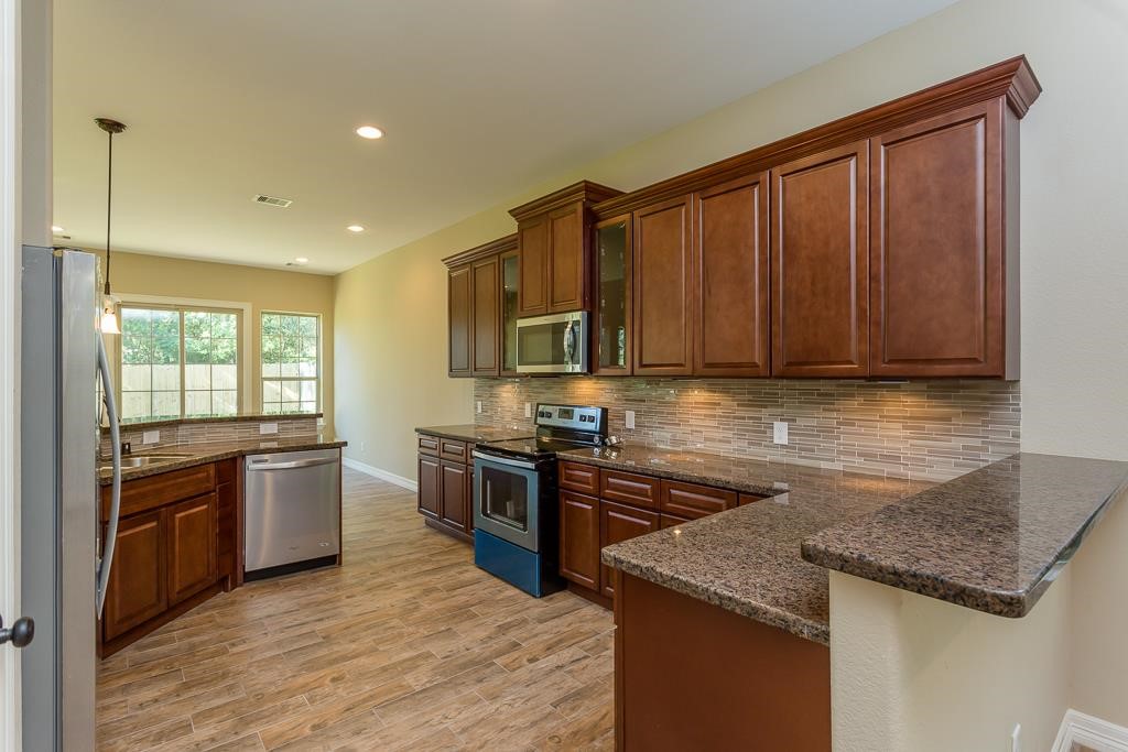 8403 Oak Knot Drive Spring, TX 77389 - Photo 10 of 31 a kitchen with stainless steel appliances granite countertop hardwood floor sink stove and granite counter top