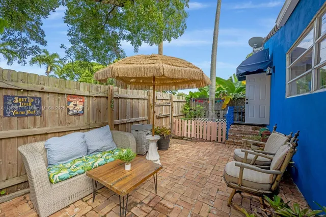 a view of a patio with a table and chairs under an umbrella