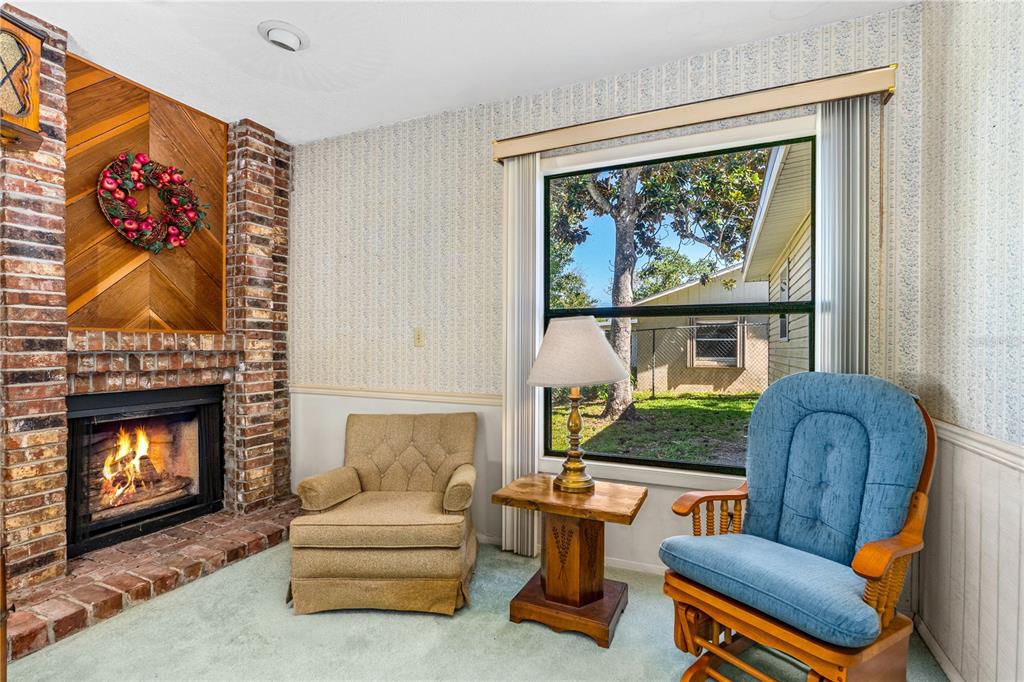693 Reillys Road Port Orange, FL 32127 - Photo 13 of 31 a living room with furniture a fireplace and a large window
