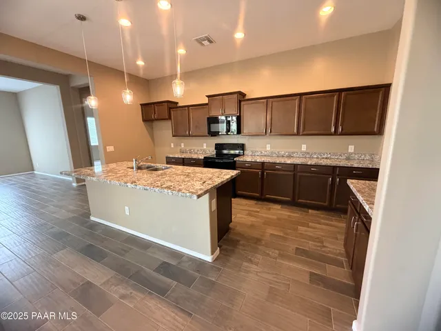 a kitchen with stainless steel appliances granite countertop a sink stove and refrigerator