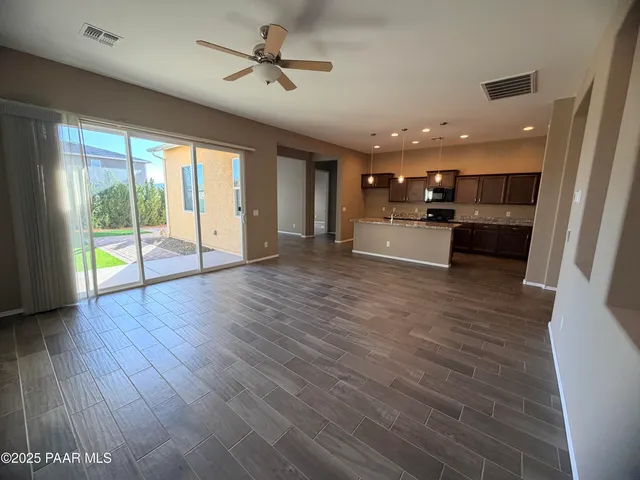 a large living room with stainless steel appliances wooden floors and view living room