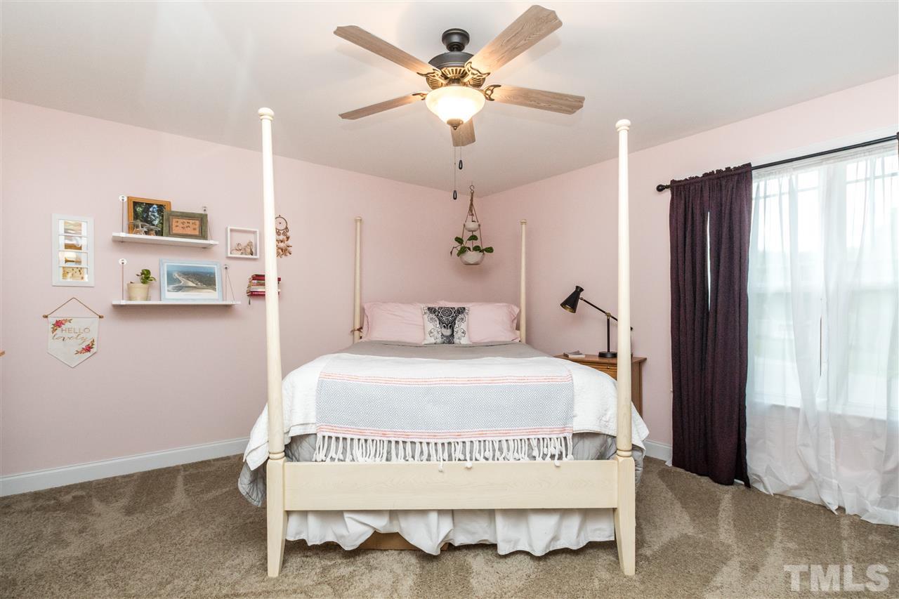 44 Henry Rifle Lane Angier, NC 27501 - Photo 13 of 22 a bed room with a bed and a chandelier