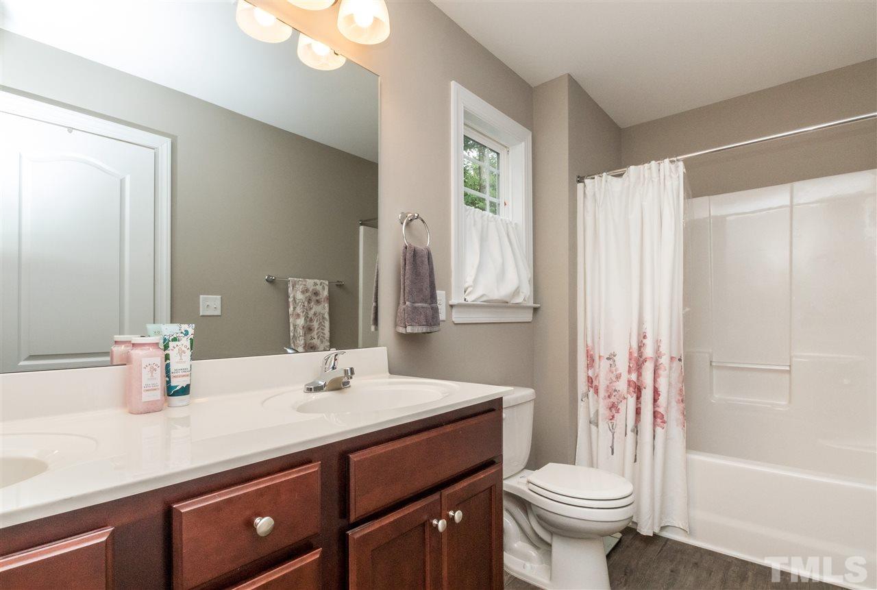 44 Henry Rifle Lane Angier, NC 27501 - Photo 15 of 22 a bathroom with a double vanity sink toilet and shower