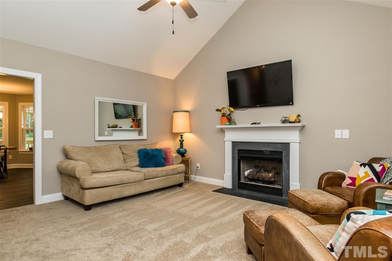 44 Henry Rifle Lane Angier, NC 27501 - Photo 3 of 22 a living room with furniture a flat screen tv and a fireplace