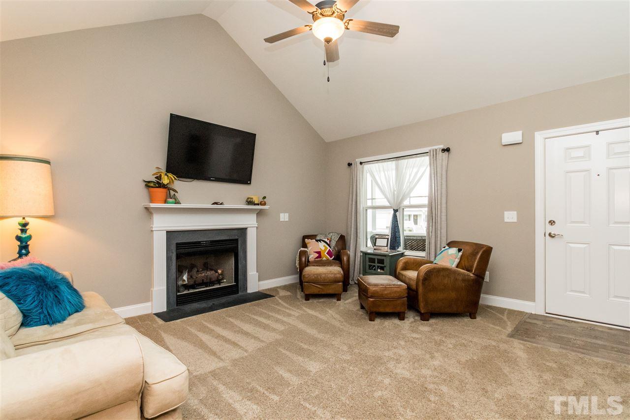 44 Henry Rifle Lane Angier, NC 27501 - Photo 4 of 22 a living room with furniture a fireplace and a flat screen tv