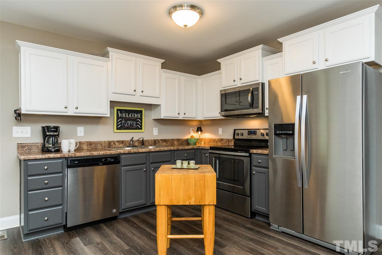44 Henry Rifle Lane Angier, NC 27501 - Photo 8 of 22 a kitchen with stainless steel appliances granite countertop a refrigerator stove microwave and sink