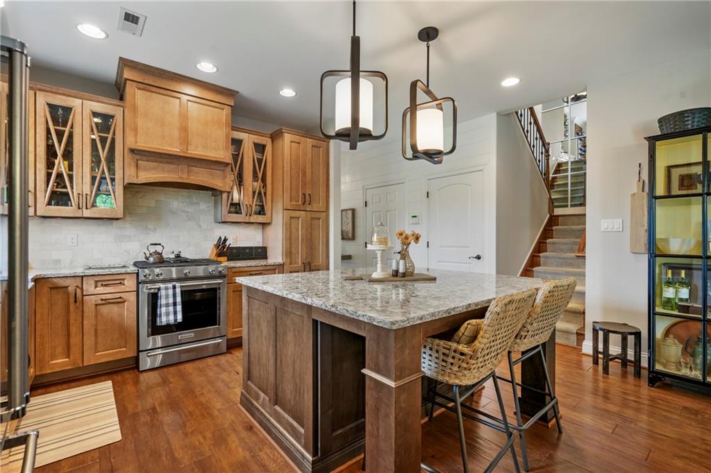 107 Resolution Drive Mars, PA 16046 - Photo 6 of 44 a kitchen with stainless steel appliances granite countertop a kitchen island a stove a sink dishwasher a dining table and chairs with wooden floor