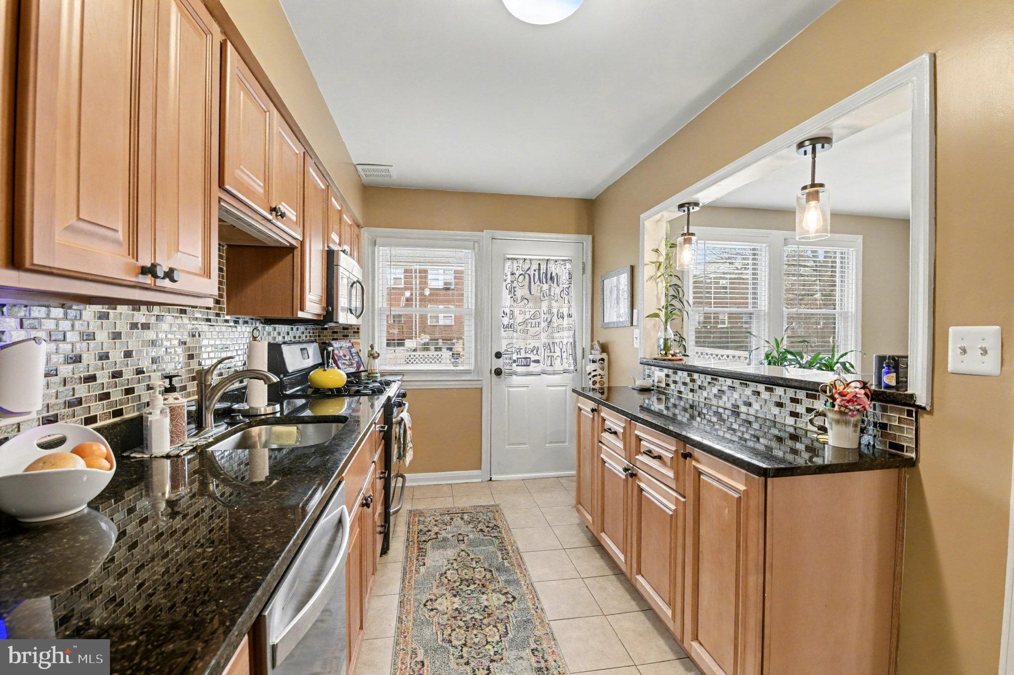 1510 Medford Road Baltimore, MD 21218 - Photo 11 of 30 a kitchen with a stove a sink a microwave and refrigerator