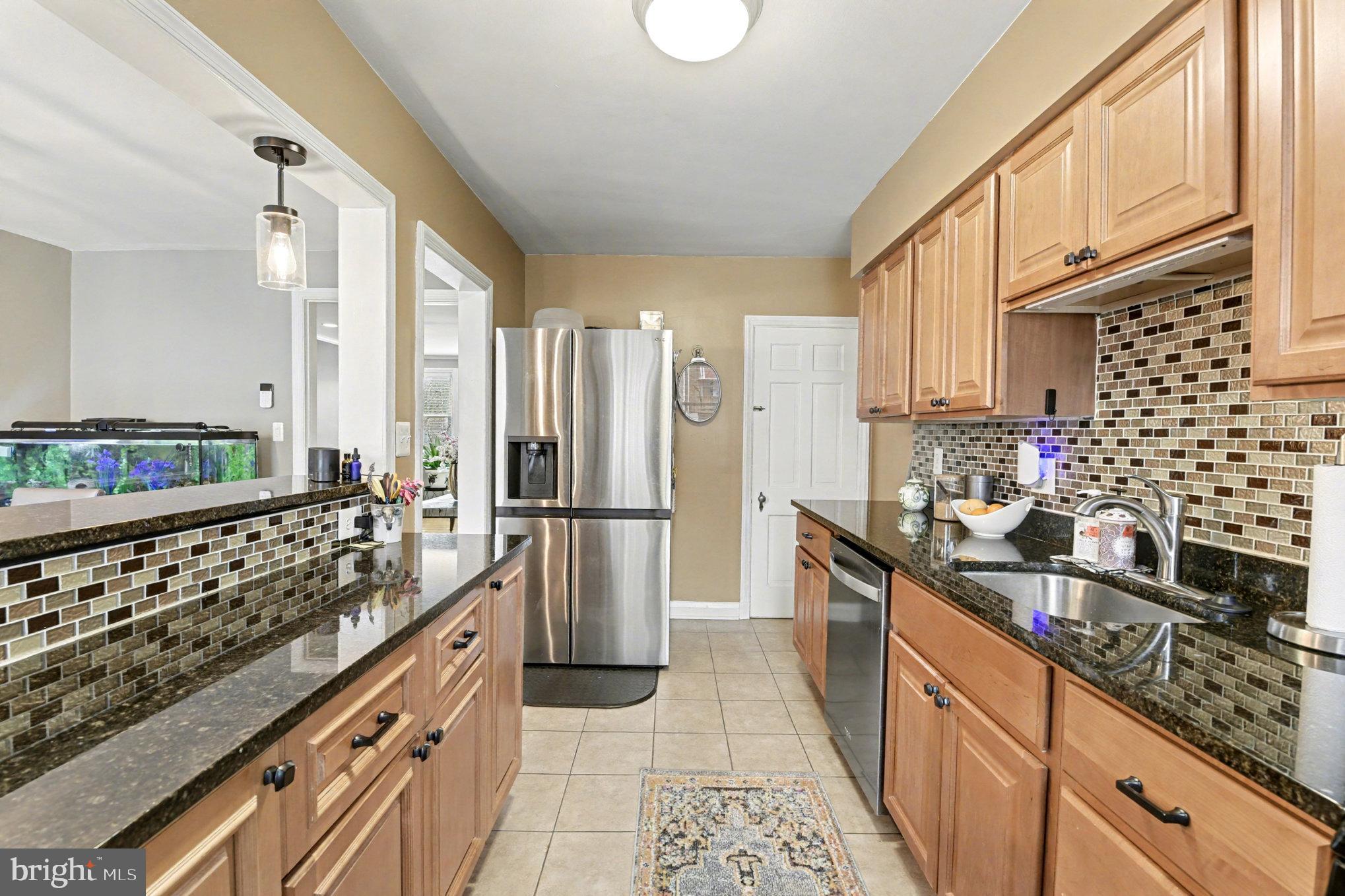 1510 Medford Road Baltimore, MD 21218 - Photo 12 of 30 a kitchen with stainless steel appliances a stove a sink dishwasher a refrigerator and cabinets with wooden floor