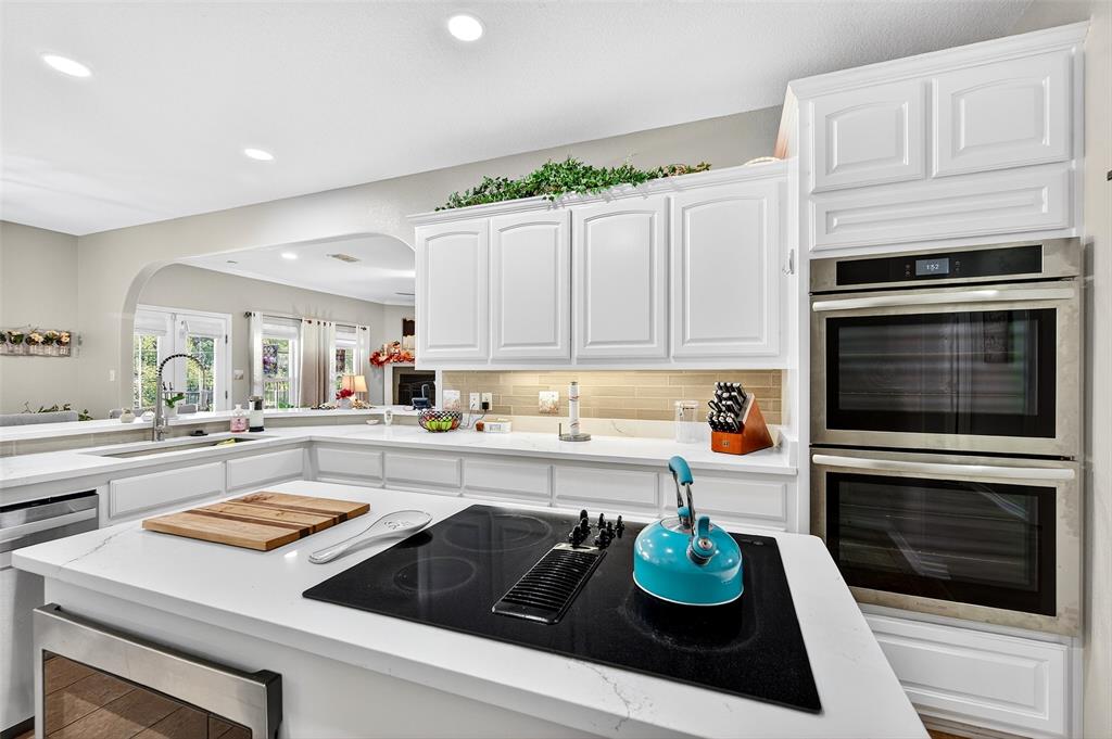 202 Hillside Lindsay, TX 76250 - Photo 11 of 37 a kitchen with kitchen island granite countertop white cabinets and white appliances