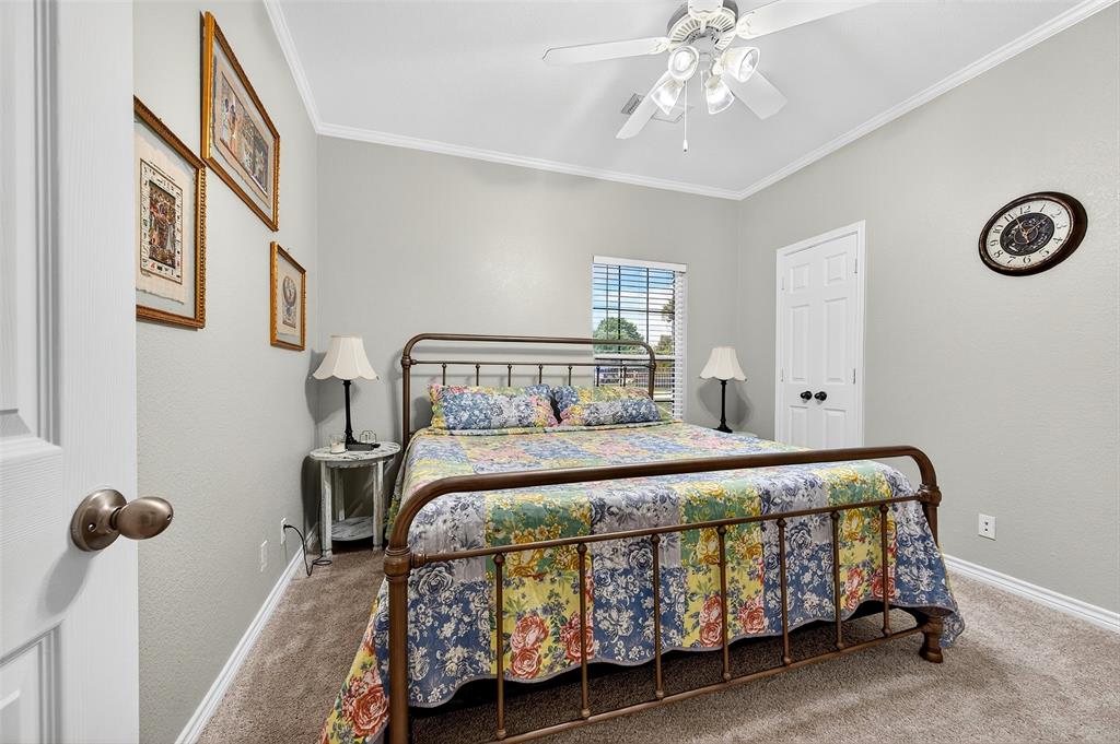 202 Hillside Lindsay, TX 76250 - Photo 14 of 37 a bedroom with a bed and a chandelier